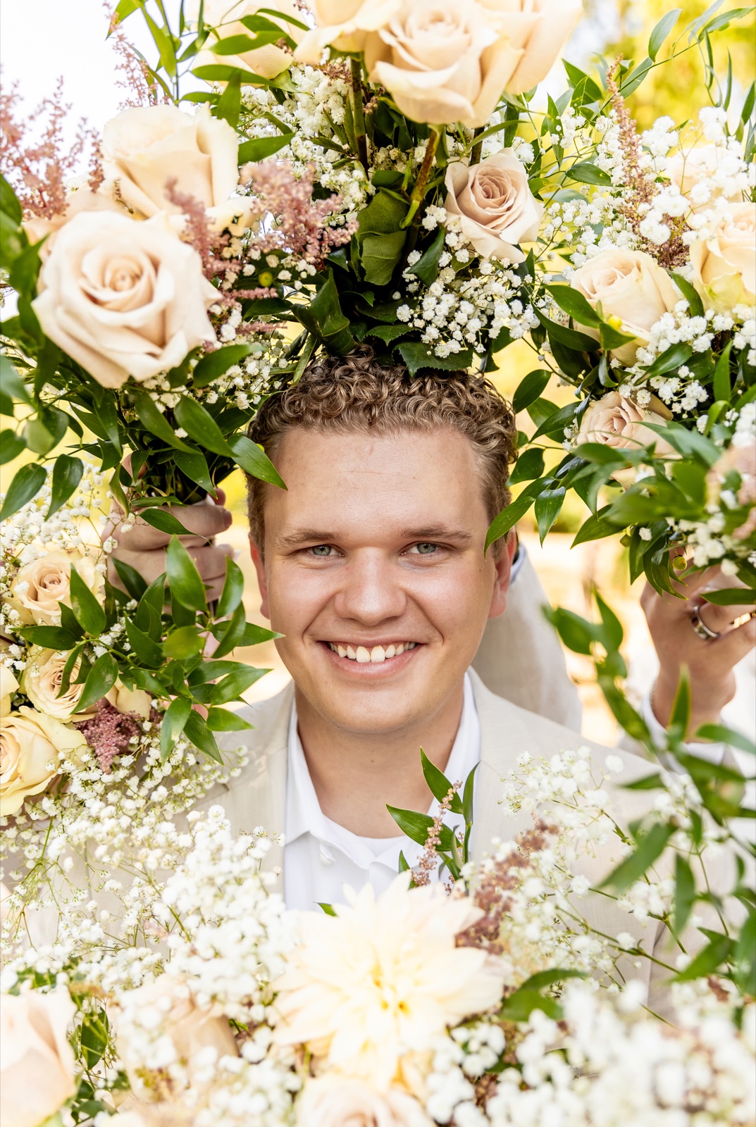 Trent Corrill smiling among flowers.
